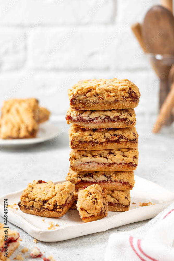 Shortbread cookies with cherry jam on a white plate on a light gray kitchen table. Delicious homemade sweet pastries Shortbread cookies with cherry jam on a white plate on a light gray kitchen table. Delicious homemade sweet pastries