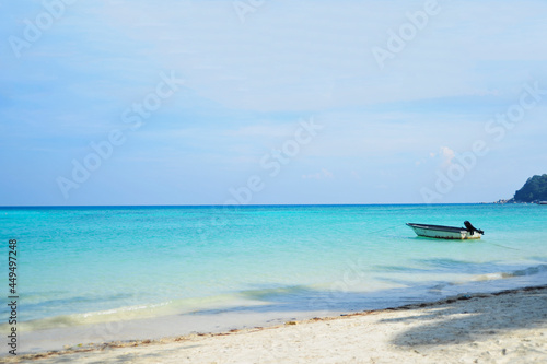 Empty beach with one small boat and calm sea with small ripples and clear skies. Selective focus points. © hmzphotostory