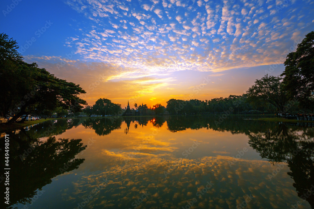Colorful sunrise and reflections at Sukhothai Historical Park.
