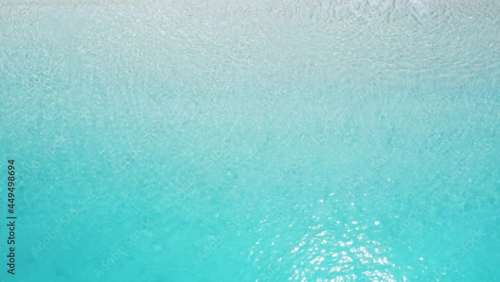 Top down static view of idyllic beach and turquoise sea with waves crushing, summer holidays background. Top down static view of idyllic beach and turquoise sea with waves crushing, summer holidays background.