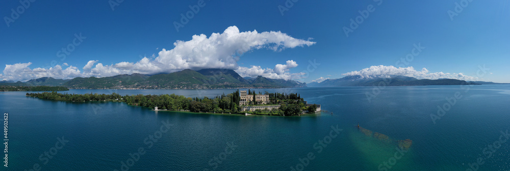 Magnificent aerial panorama of Isola del Garda, Lake Garda, Italy. Castle on an island in Italy. Historic sites on Lake Garda. An island surrounded by the Italian Alps. Isola del Garda, Italy.