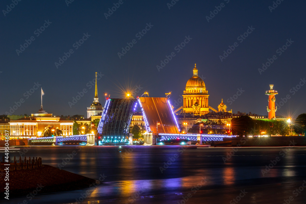 Saint Petersburg cityscape with open Palace bridge, St. Isaac's cathedral, Admiralty building and Rostral column at night, Russia
