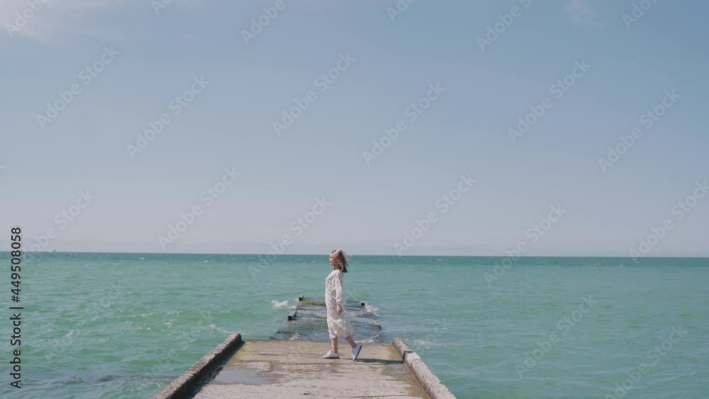 Young caucasian woman jumping and dancing on pier. Young caucasian woman jumping and dancing on pier.