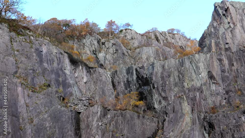 Panning shot of steep rock walls in disused slate quarry in autumn. Panning shot of steep rock walls in disused slate quarry in autumn.
