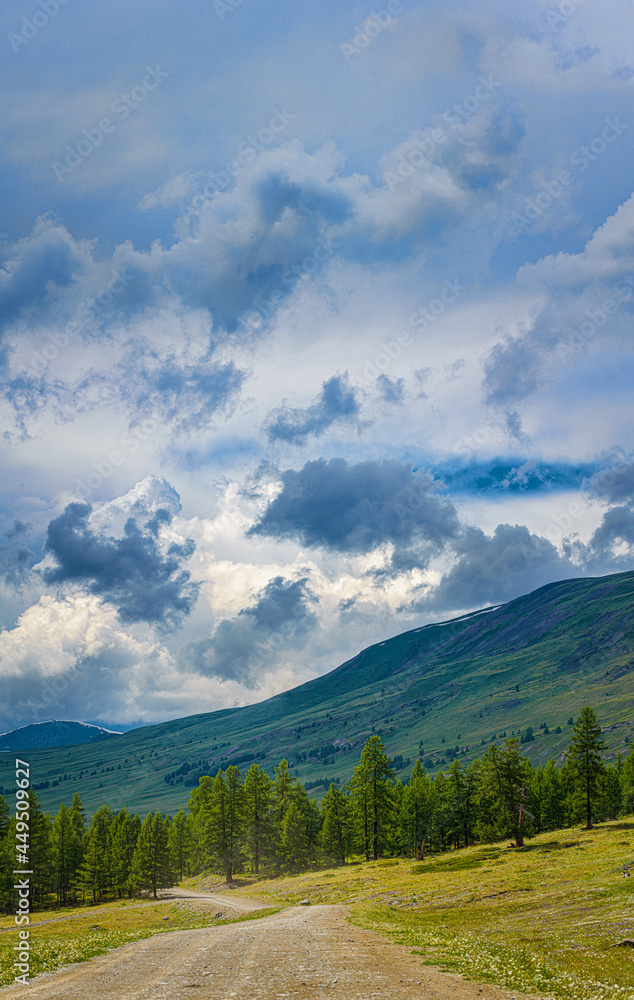 Obraz premium picturesque view of plain with lake near hills and mountains under white fluffy clouds in blue sky at sunny day
