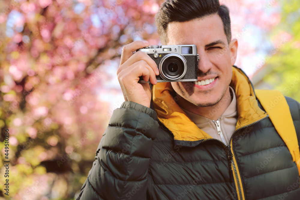 Happy male tourist with camera outdoors on spring day
