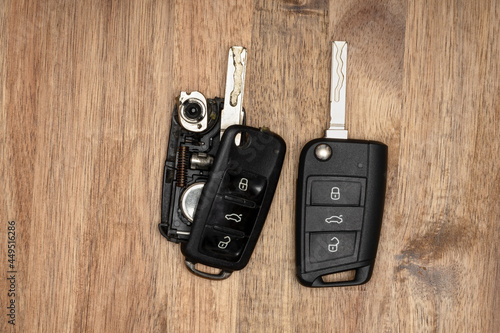 Broken Or Damaged Car Key Fob On Wooden Background. Repair Of Broken Or Damaged Remote Key Fob Locksmith Car Service.