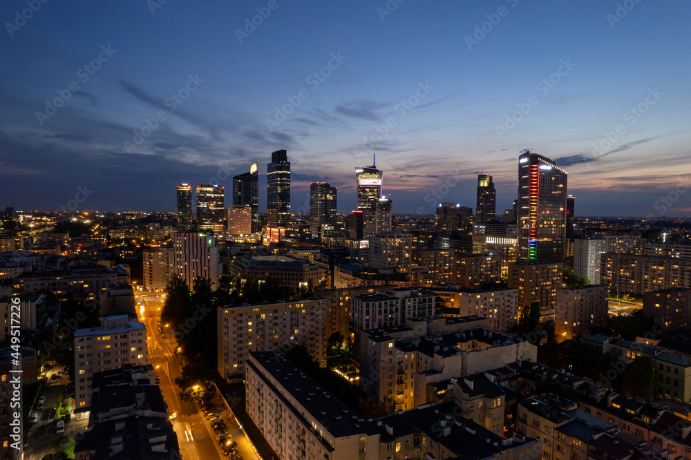 Obraz premium Warsaw by night. Amazing lights, skyscrapers and bridges over the Vistula River. View of the glowing lights in Warsaw from the drone. The capital of Poland miraculously shown at night.