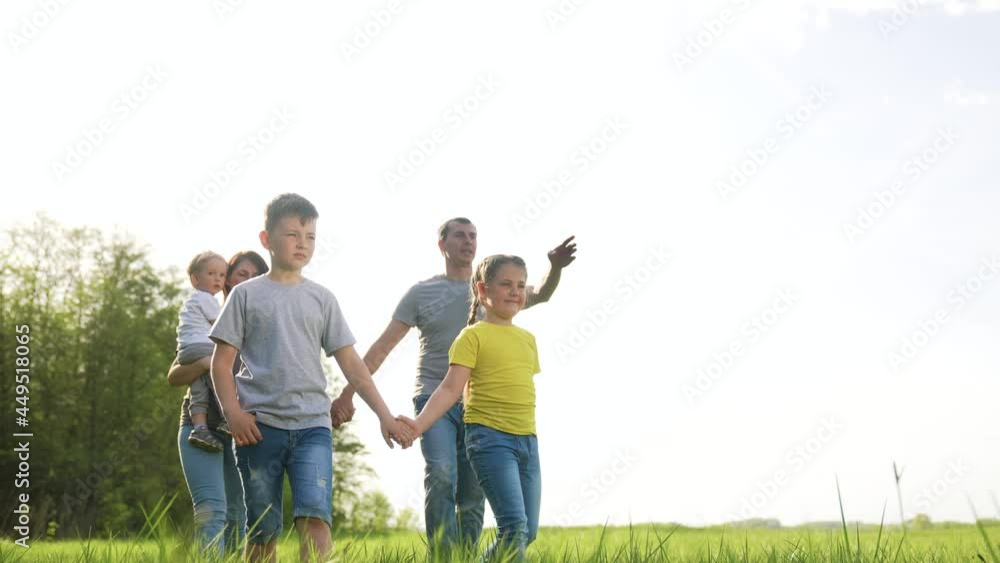 people in the park. happy family kid walk at sunset. mom dad and daughter baby walk holding hands in the park. happy family kid concept. parents and fun children. people walk dream in a green park people in the park. happy family kid walk at sunset. mom dad and daughter baby walk holding hands in the park. happy family kid concept. parents and fun children. people walk dream in a green park