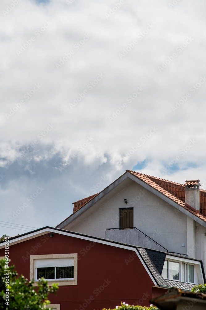 side facades of single-family houses with water-laden clouds