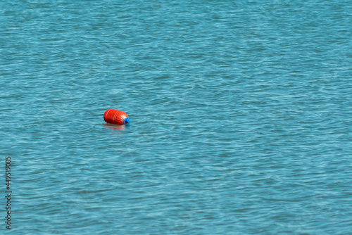 Orange homemade buoy bordering the area on the water.