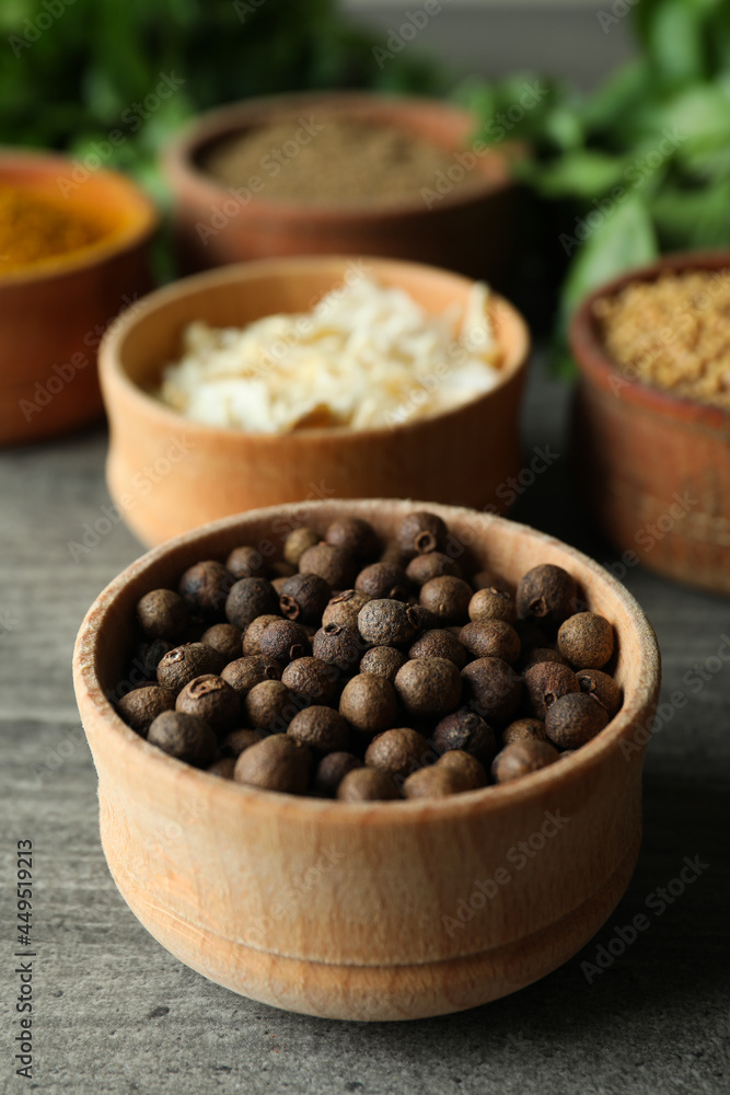 Different spices in wooden bowls on gray textured background Different spices in wooden bowls on gray textured background