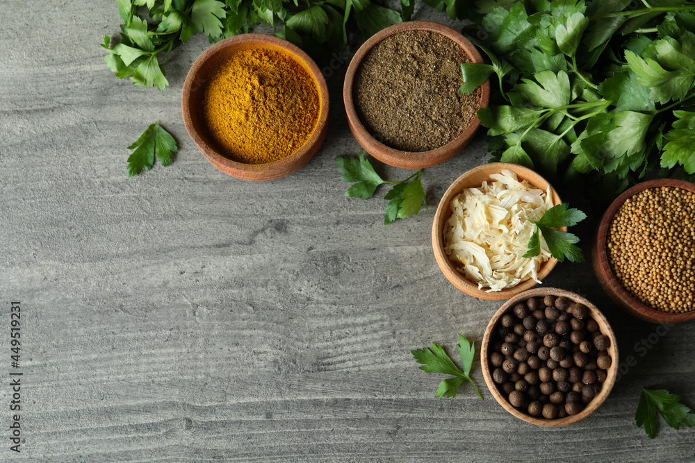 Different spices in wooden bowls on gray textured background Different spices in wooden bowls on gray textured background