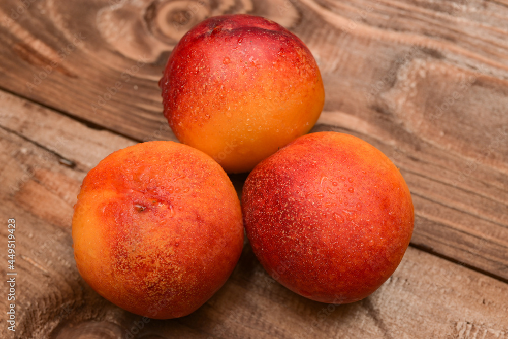 ripe yellow apricots with water drops on brown plank table ripe yellow apricots with water drops on brown plank table