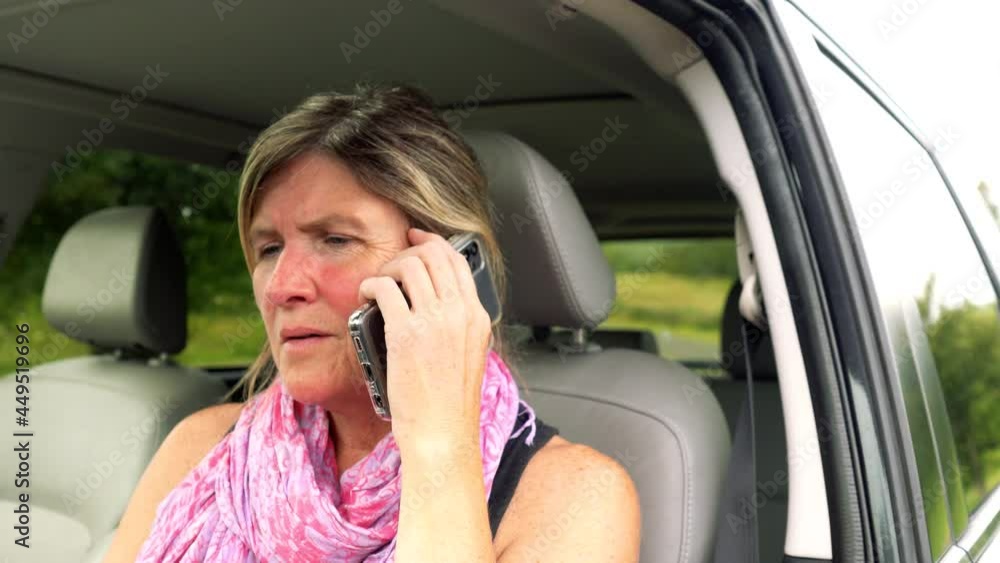Concerned woman on her cell phone sitting in her parked car Concerned woman on her cell phone sitting in her parked car