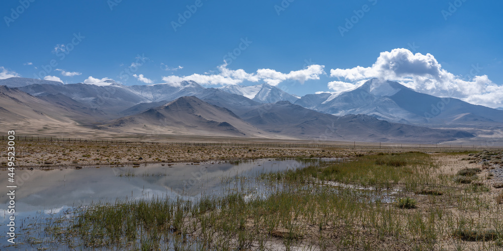 Beautiful high altitude mountain landscape with reflection in water around Karakul lake on Pamir Highway, Murghab, Gorno-Badakshan, Tajikistan