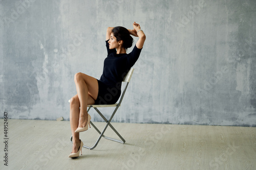 a woman in a black dress sits on a posing chair Studio Moda luxury