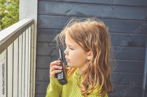 the girl child is talking on the radio on a sunny summer day