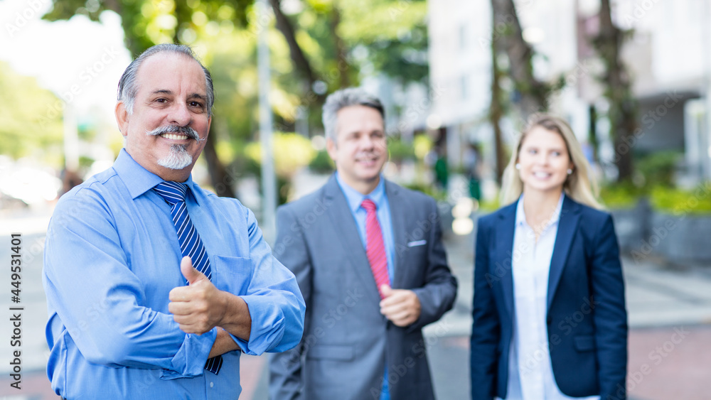 Smart mexican senior businessman with colleagues showing thumb up Smart mexican senior businessman with colleagues showing thumb up