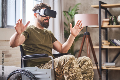 Disabled ex-serviceman in a wheelchair using a VR headset photo