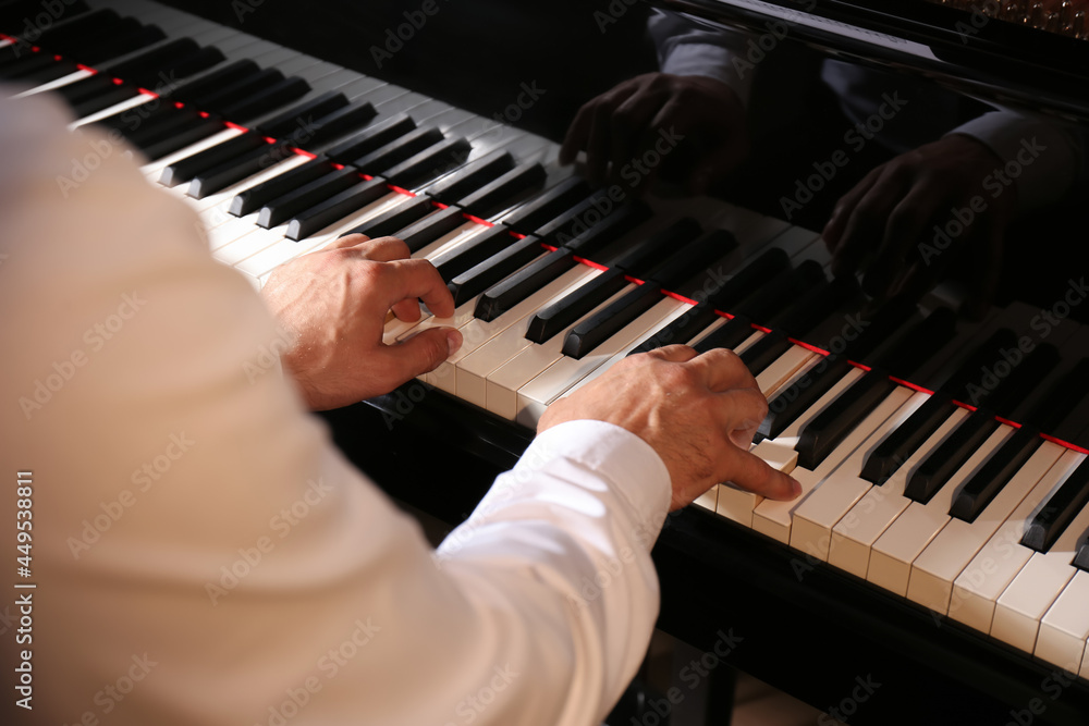 Fototapeta premium Man playing grand piano, closeup. Talented musician
