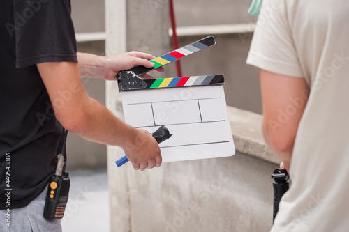 Filming on location. Man holding a clapperboard in front of the camera, the filming process. Scene on location