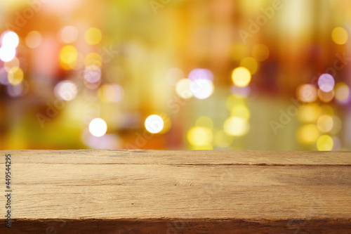 Empty wooden table over abstract blurred restaurant lights background.  Mock up for design and product display.