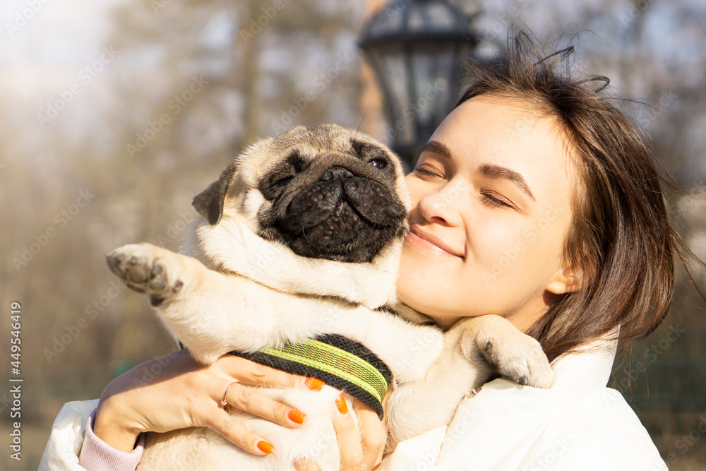Smiling Girl kissing hugging pug dog pet cute . closeup closing eyes. funny animals . Happy time with pet concept . Smiling Girl kissing hugging pug dog pet cute . closeup closing eyes. funny animals . Happy time with pet concept .