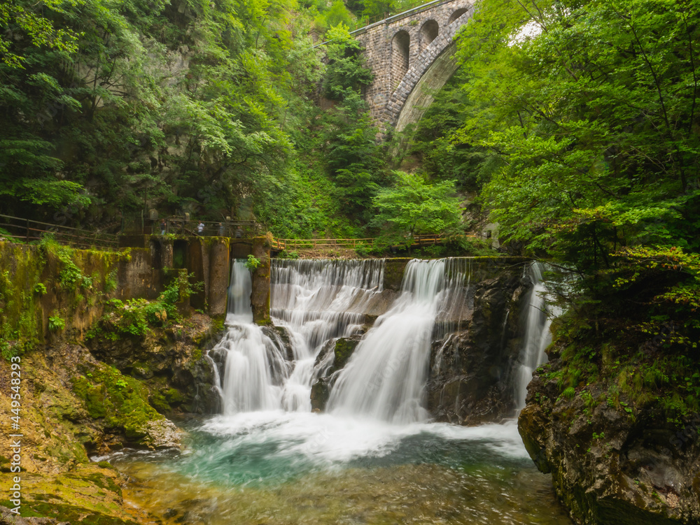 Vintgar gorge, Slovenia. River near the Bled lake with wooden tourist paths, bridges above river and waterfalls. Hiking in the Triglav national park. Fresh nature, blue water in the forest.