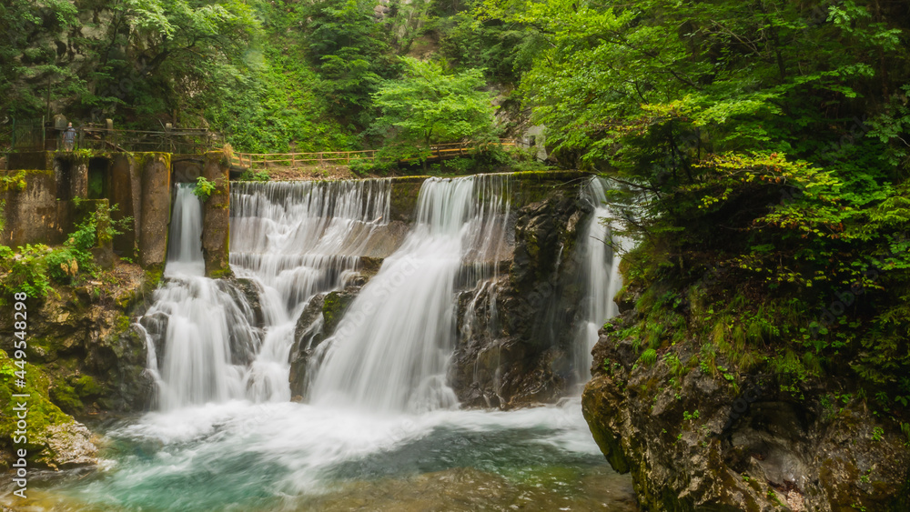 Vintgar gorge, Slovenia. River near the Bled lake with wooden tourist paths, bridges above river and waterfalls. Hiking in the Triglav national park. Fresh nature, blue water in the forest.