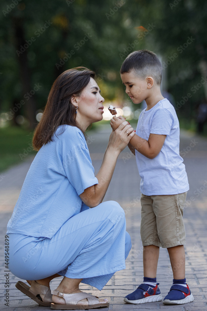 Boy and mother eat ice cream in the summer park. Boy and mother eat ice cream in the summer park.