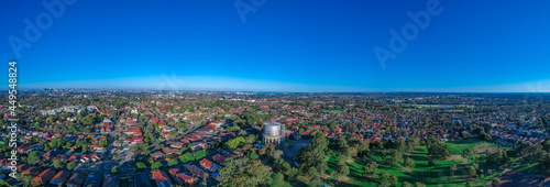 Panoramic Aerial Drone view of Suburban Sydney housing, roof tops, the streets and the parks and CBD Skyline NSW Australia