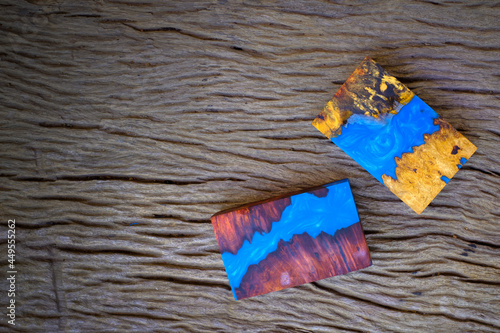 Cube casting epoxy resin with nature burl BURMA PADAUK and maple wood on the old table photo