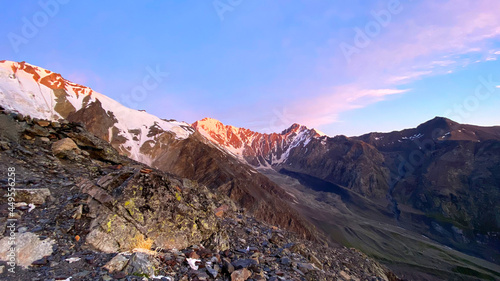 Dawn in the mountains. Majestic beautiful mountains, hills, cliffs and a glacier. Climbing Kazbek
