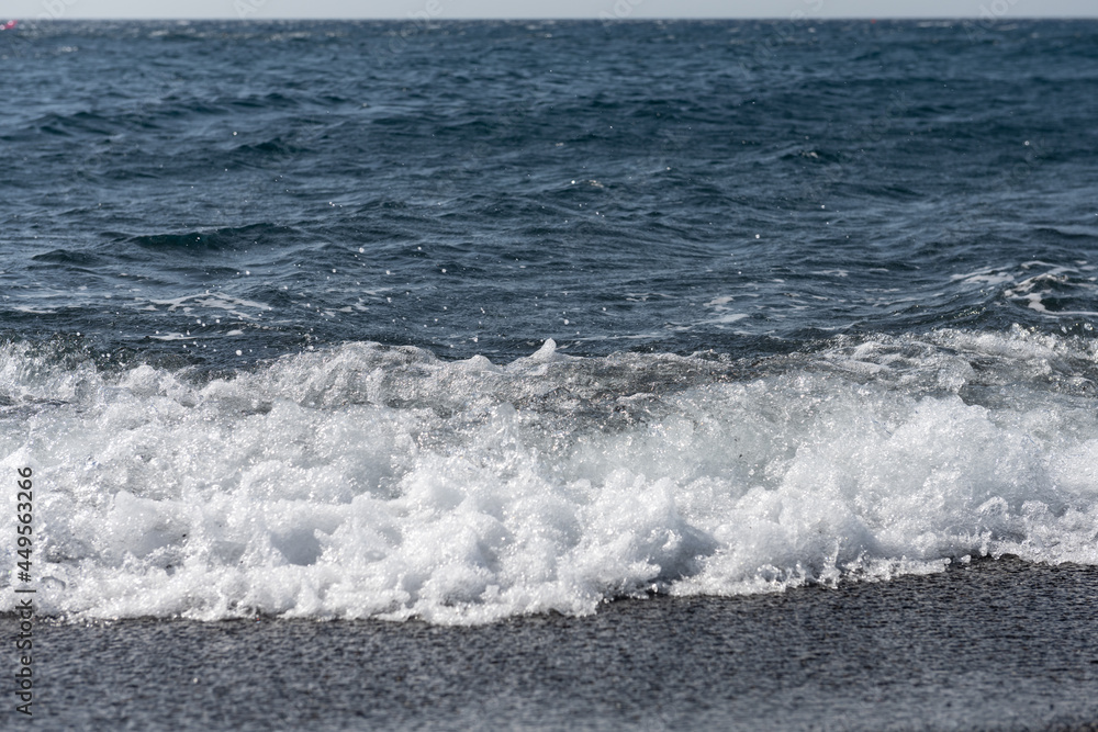 empty Black Sand beach in Santorini Greece early morning with small waves. empty Black Sand beach in Santorini Greece early morning with small waves.