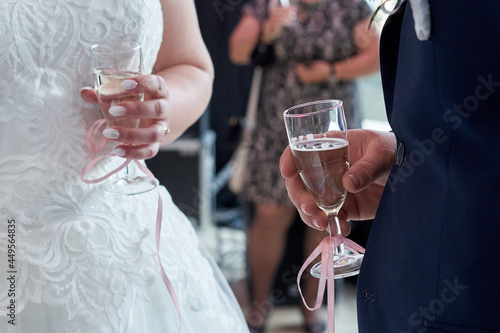 Hand of groom and bride holding glass of champaigne