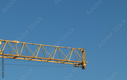 Crane steel cantilever ending on blue sky background