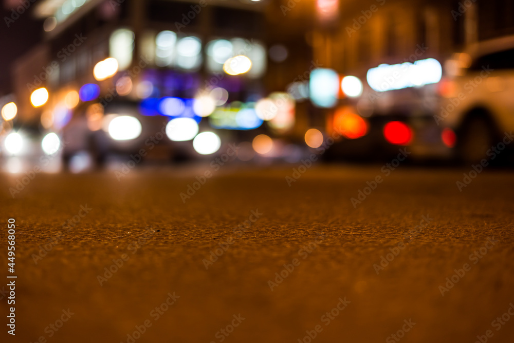 Nights lights of the big city, close up view from asphalt level on the lights of cars Nights lights of the big city, close up view from asphalt level on the lights of cars