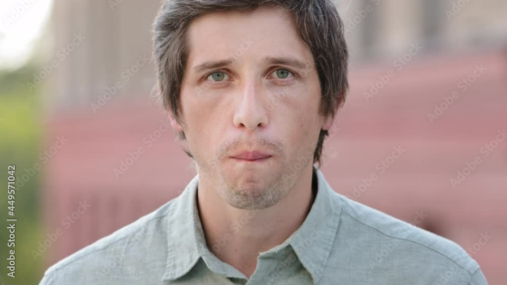 Millennial guy holds beautiful ripe apple in his hand, takes bite with pleasure, chews, makes terrible grimace. Young man tasted it and grimaced. Advertising victim, false review, disappointed concept Millennial guy holds beautiful ripe apple in his hand, takes bite with pleasure, chews, makes terrible grimace. Young man tasted it and grimaced. Advertising victim, false review, disappointed concept