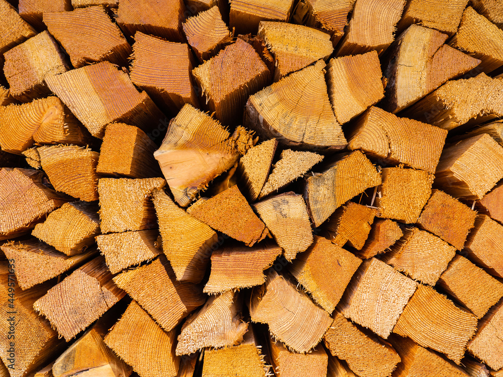 Firewood cut and stacked. Wall of wooden pieces. Warm colors with shades of brown. Wood stacked with precision. Wooden natural cut logs texture background Firewood cut and stacked. Wall of wooden pieces. Warm colors with shades of brown. Wood stacked with precision. Wooden natural cut logs texture background