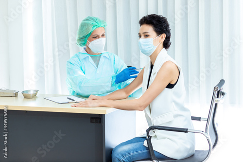 medicine  vaccination and healthcare concept - doctor wearing face protective medical mask for protection from virus disease with syringe doing injection of vaccine to a patient