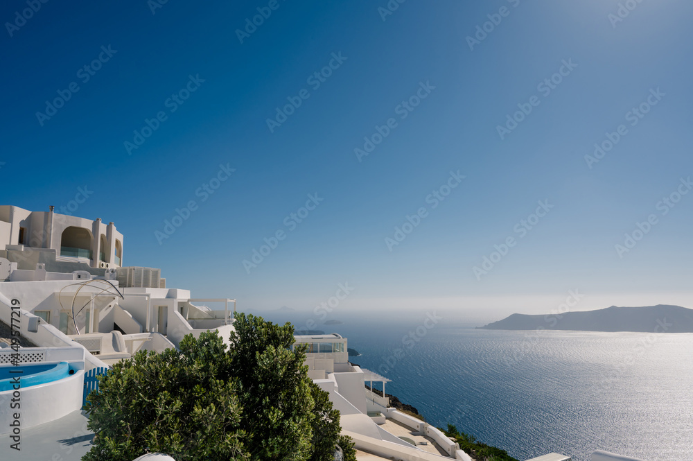 Fototapeta premium View of caldera and white architecture of Imerovigli on Santorini island, Greece. Volcano in sea. Luxury vacation.