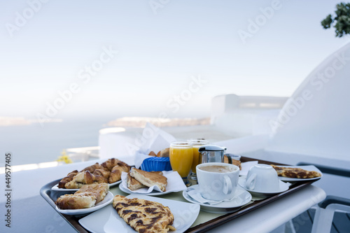 Breakfast on terrace vith view of sea. Santorini island, Greece. Luxury vacation.