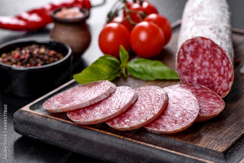 Spanish dried sausage salami on a dark concrete background Spanish dried sausage salami on a dark concrete background