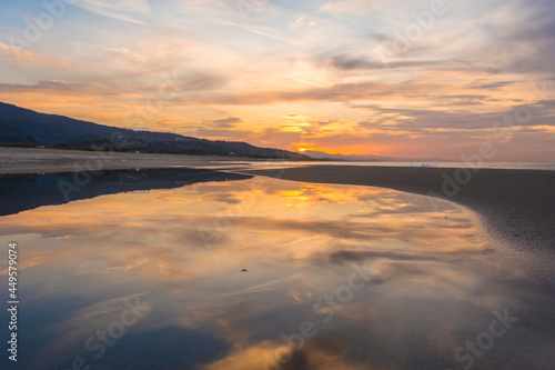 Lake in a beach, forms small lakes in the sea coast due to the tides, a pool in the sands of the seashore due to the waves, a landscape of pools in beach at sunset, sea and ocean with sky and clouds.