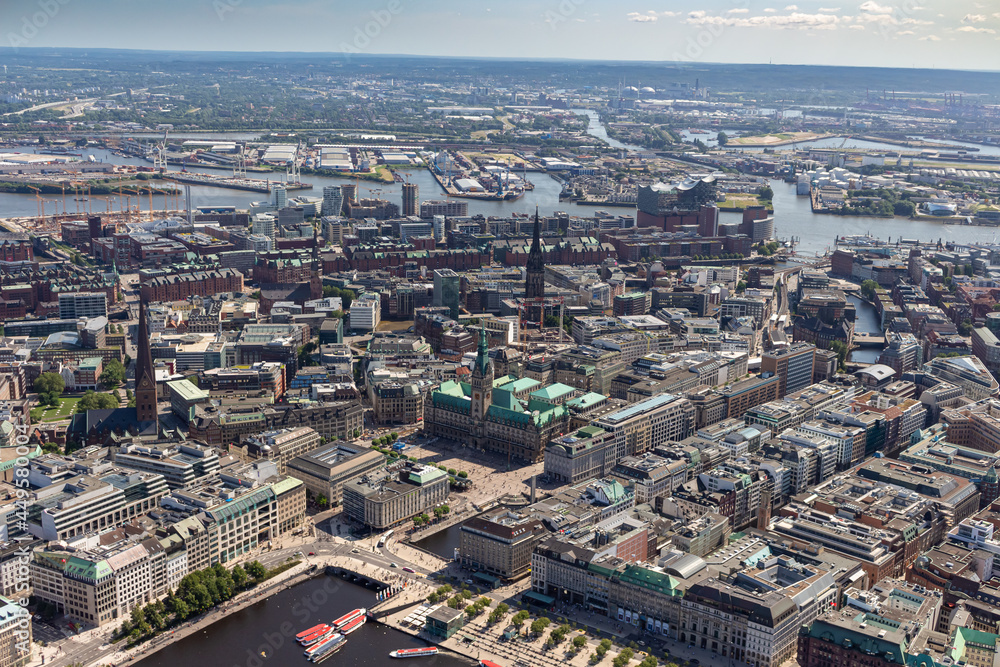 Obraz premium Luftbildaufnahme der Hansestadt Hamburg mit der Alster, dem Stadtpark, der Hafen City, dem Conatinerterminal und Conatinerschiffen sowie weiteren Wahrzeichen der Stadt Hamburg, wie die Elbphilharmonie
