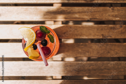 Italian soda syrup of mixed berries and lemon served on wooden desk in summer.