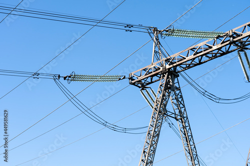 a line of high-voltage wires on a blue sky background