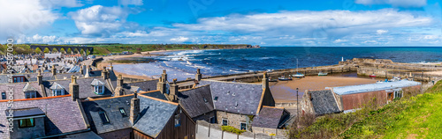 A view across the roof tops and the beach of the town of  Cullen, Scotland on a summers day photo