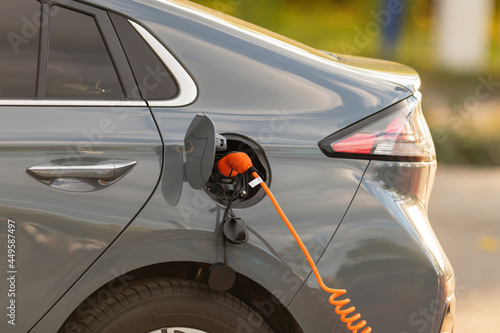 Ein Elektroauto hat das Ladekabel eingesteckt photo